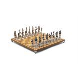 A SILVER 'EGYPTIAN AND NUBIANS' CHESS SET AND CHESS BOARD, SPANISH 20TH CENTURY, modelled as