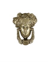 A GEORGIAN STYLE BRASS DOOR KNOCKER, in the form of a Classical female head with swag knocker. 18