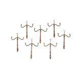 A SET OF SEVEN MAHOGANY AND BRASS MOUNTED WIG STANDS, each surmounted with suspension hook, and wavy
