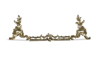 A PAIR OF 19TH CENTURY BRASS FIRE DOGS, in the form of acanthus leaf sprays. and a rococo curb