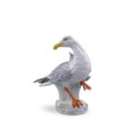 A 20TH CENTURY MEISSEN PAINTED PORCELAIN MODEL OF A SEAGULL standing in rushes on a rocky oval base,