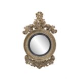 A MONUMENTAL REGENCY CARVED GILTWOOD CONVEX MIRROR, surmounted by armorial and flanked by acanthus