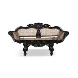 AN ANGLO-INDIAN CARVED EBONY DOUBLE SCROLL END SETTEE, with tall cresting, panelled cane back and