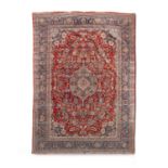 A LARGE SEMI-ANTIQUE KASHAN WOOL CARPET, the red ground centered with a pale blue medallion within a