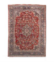 A LARGE SEMI-ANTIQUE KASHAN WOOL CARPET, the red ground centered with a pale blue medallion within a