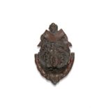 AN EDWARDIAN BRONZE DOOR KNOCKER cast in the form of a female mask. 21cm high