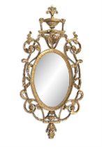 A FINE IRISH GILTWOOD AND GESSO MIRROR, c.1770, the oval plate within a foliate and ribbon pierced