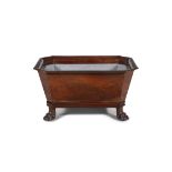 AN IRISH REGENCY MAHOGANY WINE COOLER of tapering rectangular shape, with angled corners and cast