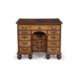 A GEORGE II WALNUT KNEEHOLE DESK, C.1750 the cross-banded top with feathered banding and fitted with