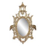 A GEORGE III CARVED GILTWOOD OVAL CHINOISERIE MIRROR, surmounted by a pagoda, the open frame of leaf