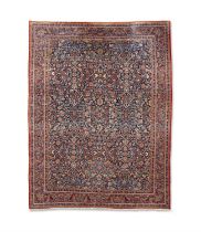 A SEMI-ANTIQUE KASHAN CARPET, C.1930. 418 X 322cm with all-over cartouche and scroll design in reds,