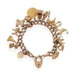 AN EDWARDIAN, 9CT GO,LD CHARM BRACELET Of curb-link design with heart-shaped clasp,