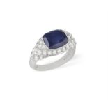 AN 18CT GOLD, SYNTHETIC SAPPHIRE AND DIAMOND RING Centering a cushion-shaped synthetic sapphire,