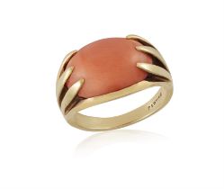 A CORAL DRESS RING, BY CARTIER The oval-shaped corallium rubrum coral cabochon within a six-claw