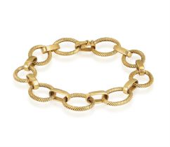A GOLD BRACELET, BY CARTIER Composed of openwork textured circular links with polished