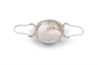 A LARGE SILVER TEA LEAF STRAINER, with mark of George Smith, London, 1783. 11cm diameter x 24.