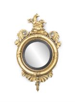 A WILLIAM IV GILTWOOD FRAMED CONVEX WALL MIRROR, the circular plate surmounted with a