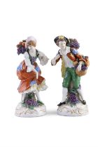 A PAIR OF CHELSEA POLYCHROME PORCELAIN FIGURES, of male and female fruit sellers. 22.6cm high