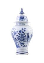 A DELFTWARE BLUE AND WHITE DECORATED CIRCULAR BALUSTER JAR AND COVER, with domed top and finial.