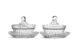 A PAIR OF IRISH REGENCY GLASS OVAL BUTTER TUBS, COVERS AND STANDS, the faceted domed lids with