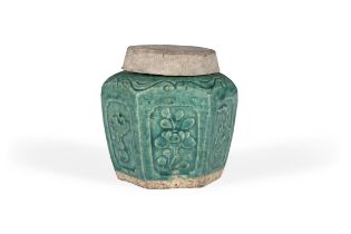 AN ANCIENT CHINESE GREEN GLAZED EARTHENWARE JAR AND COVER, decorated with floral panels in