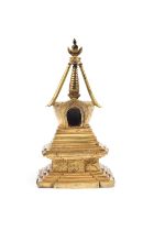 A GILT-COPPER STUPA 清十八世紀 鎏金銅佛塔 China, 18th century. An ornately decorated stupa on a