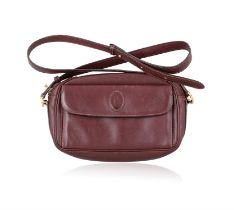A 'Must de Cartier' crossbody leather handbag and belt by Cartier The bordeaux leather handbag