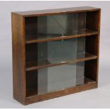 A mid-20th century oak three-tier standing bookcase each tier enclosed by a pair of glass sliding