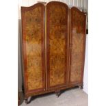 A mid-20th century burr-walnut wardrobe in the Queen Anne-style having a fitted interior enclosed by