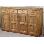 A Victorian pitch-pine dresser base fitted four frieze drawers above cupboard enclosed by two