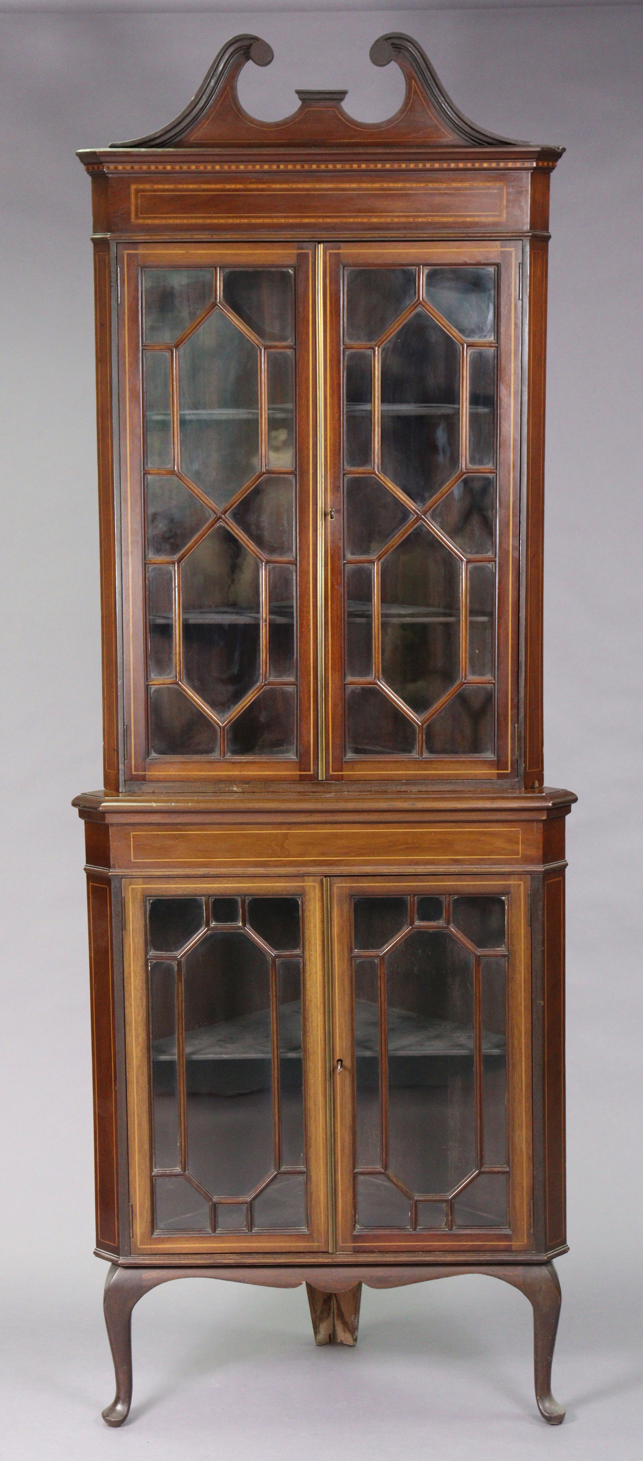 An Edwardian inlaid-mahogany tall standing corner cabinet fitted four shelves enclosed by two