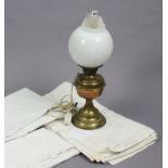 A brass oil table lamp converted to electricity (the globular opaque glass shade cracked);