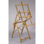 A beech fold-away artist’s studio easel, 25” wide.