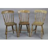 A set of three spindle-back kitchen chairs with hard seats, & on turned legs with spindle