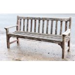 A teak slatted garden bench on square legs, 63” long.