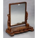 A 19th century mahogany rectangular swing toilet mirror with scroll supports, & on a serpentine-