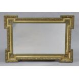 A late 19th/early 20th century aesthetic-style rectangular wall mirror, the gilt frame with raised
