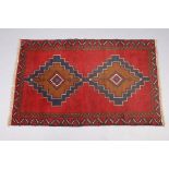 A Baluchi rug of madder ground, the central field with lozenge motifs, in narrow borders, 37” wide x