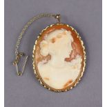 A carved shell oval cameo brooch depicting a female bust, in 14k mount with safety chain, 4.5 x 3.