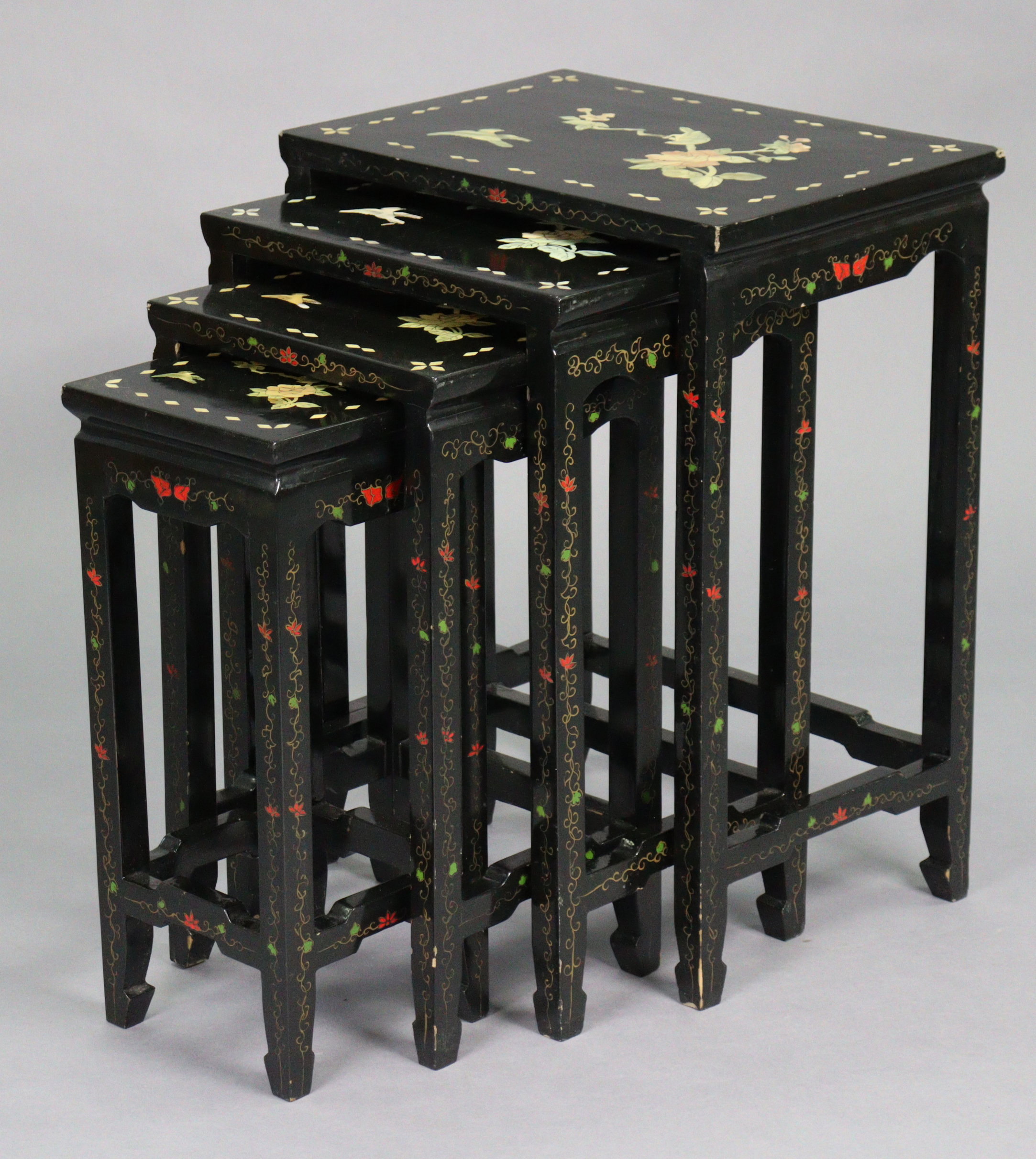 A nest of four Chinese lacquered occasional tables, each with inlaid mother-of-pearl & painted