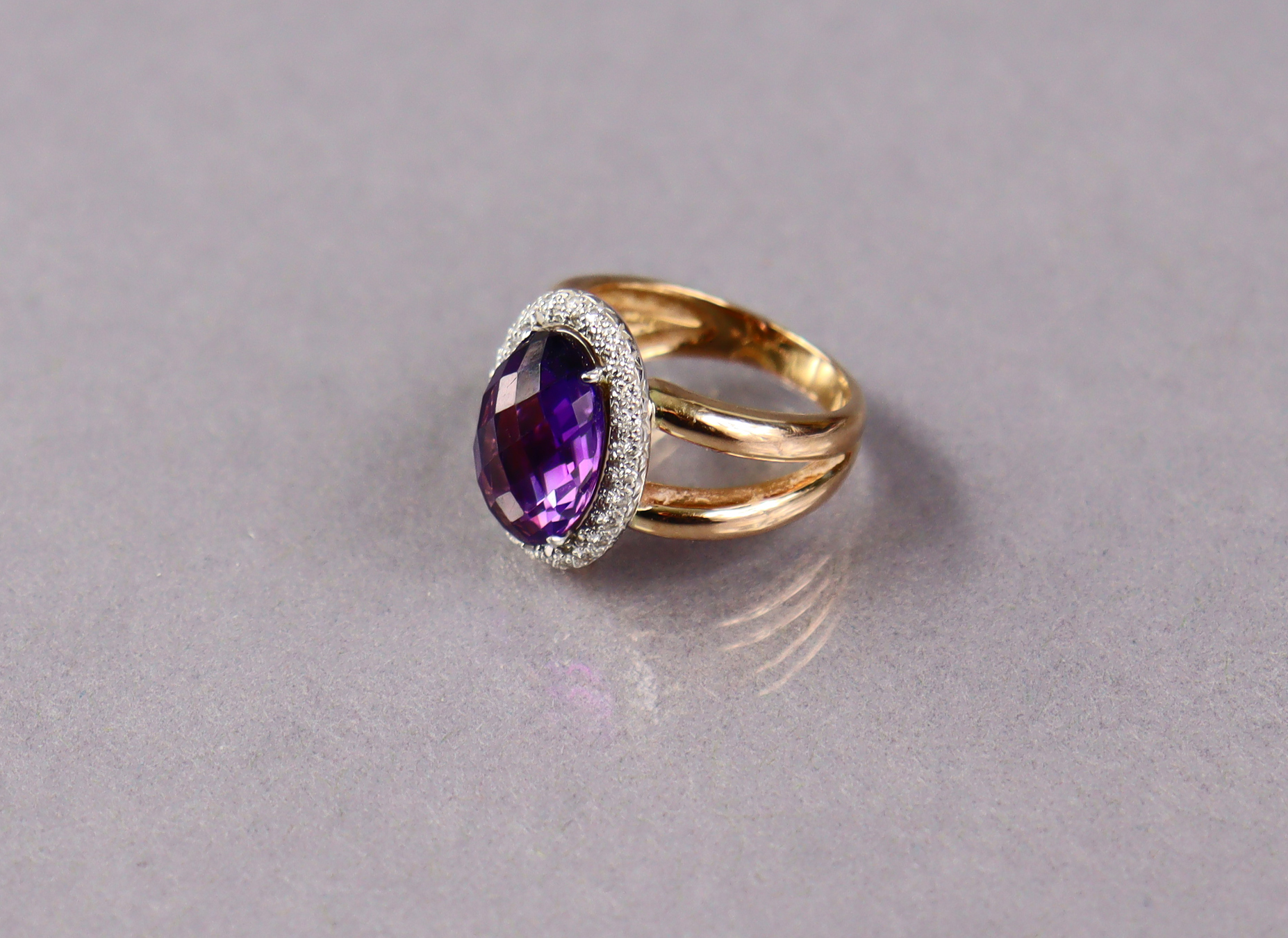 An 18ct gold ring set oval facet-cut amethyst within a border of small diamonds, size M. (7.9g) - Image 2 of 3