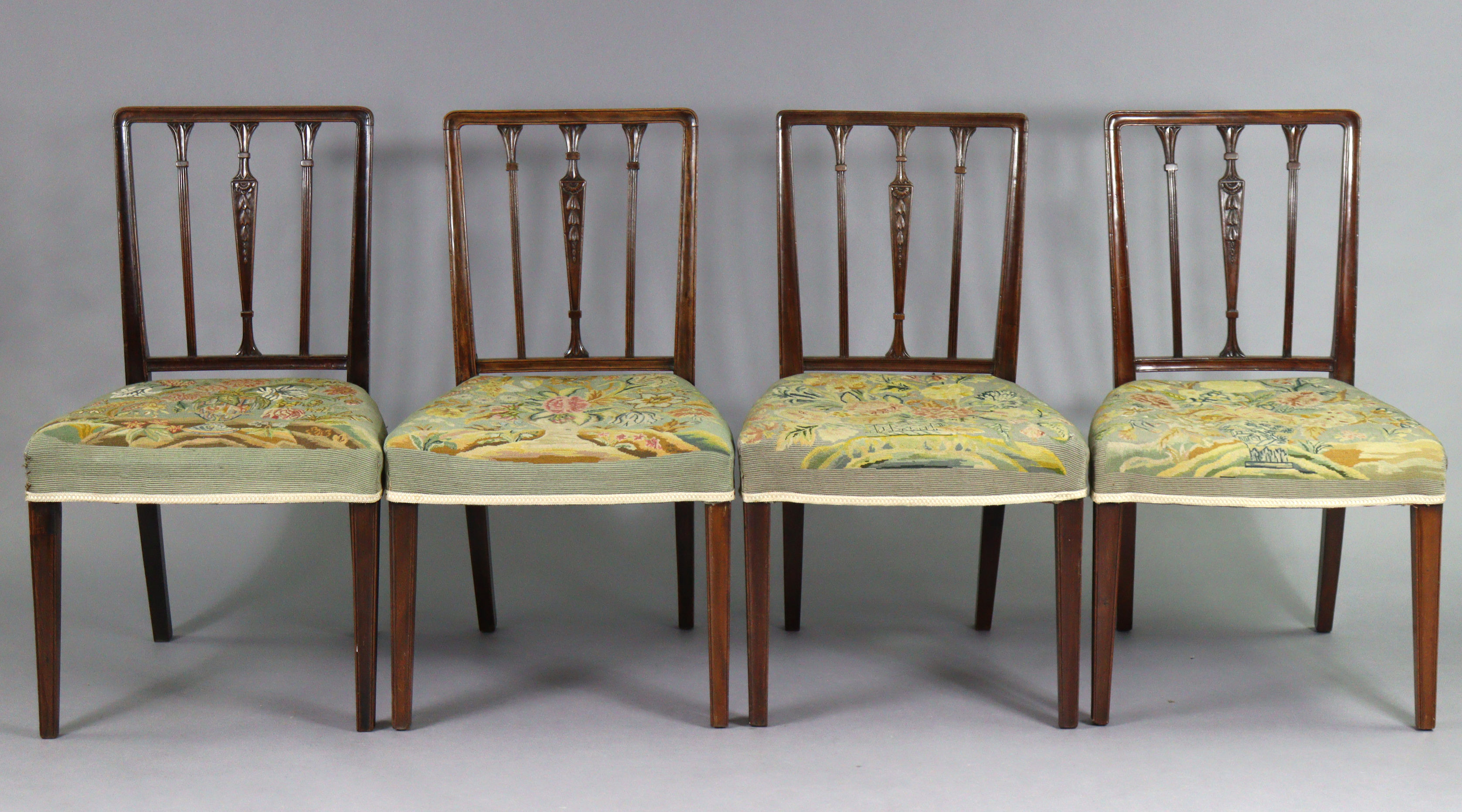 A set of four 19th century dining chairs with carved foliate decoration to the rail-backs, padded