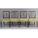 A set of four 19th century dining chairs with carved foliate decoration to the rail-backs, padded