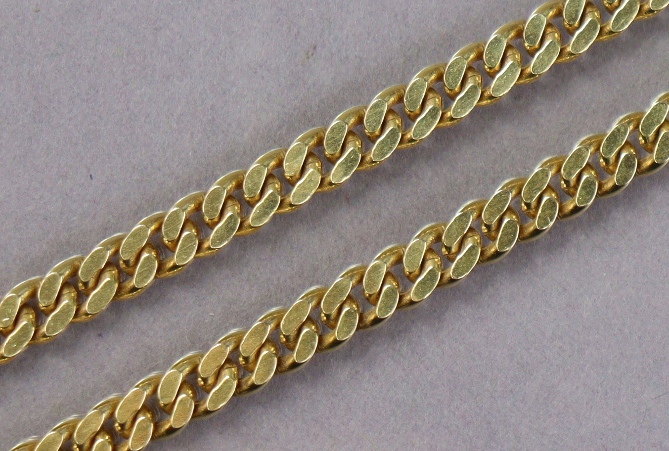 A 9ct gold chain necklace of flattened curb links, 17½” long. (30.8g)