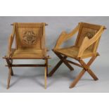 A pair of early 20th century oak Glastonbury-type elbow chairs with carved floral roundels to the