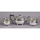 A George VI silver three-piece tea service in the regency style, of compressed oblong form with