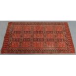 A Bokhara wall hanging of madder ground, with repeating geometric designs in multiple narrow