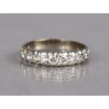A half-hoop ring set nine graduated cubic zirconia to a white metal shank marked “18ct”, size T. (3.