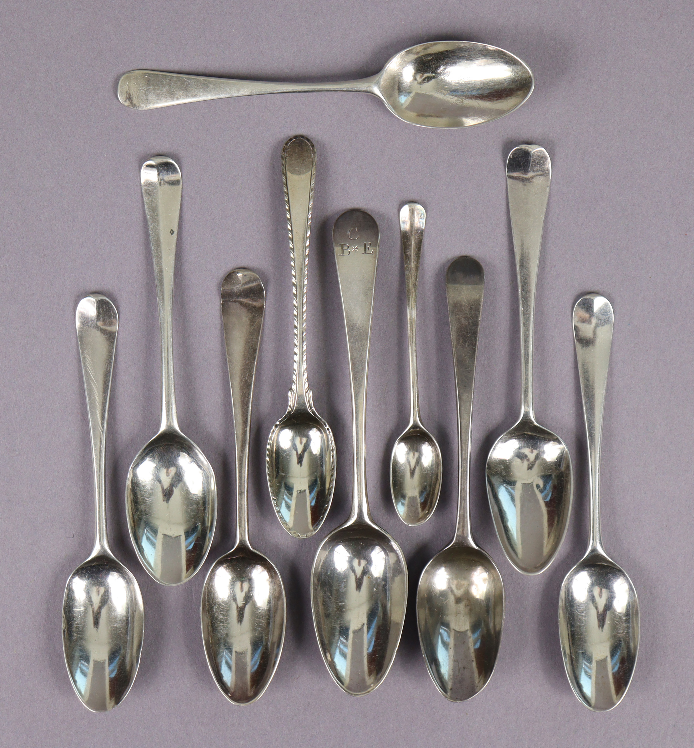 A group of nine 18th century silver teaspoons including a picture-back spoon, six shell-back spoons;