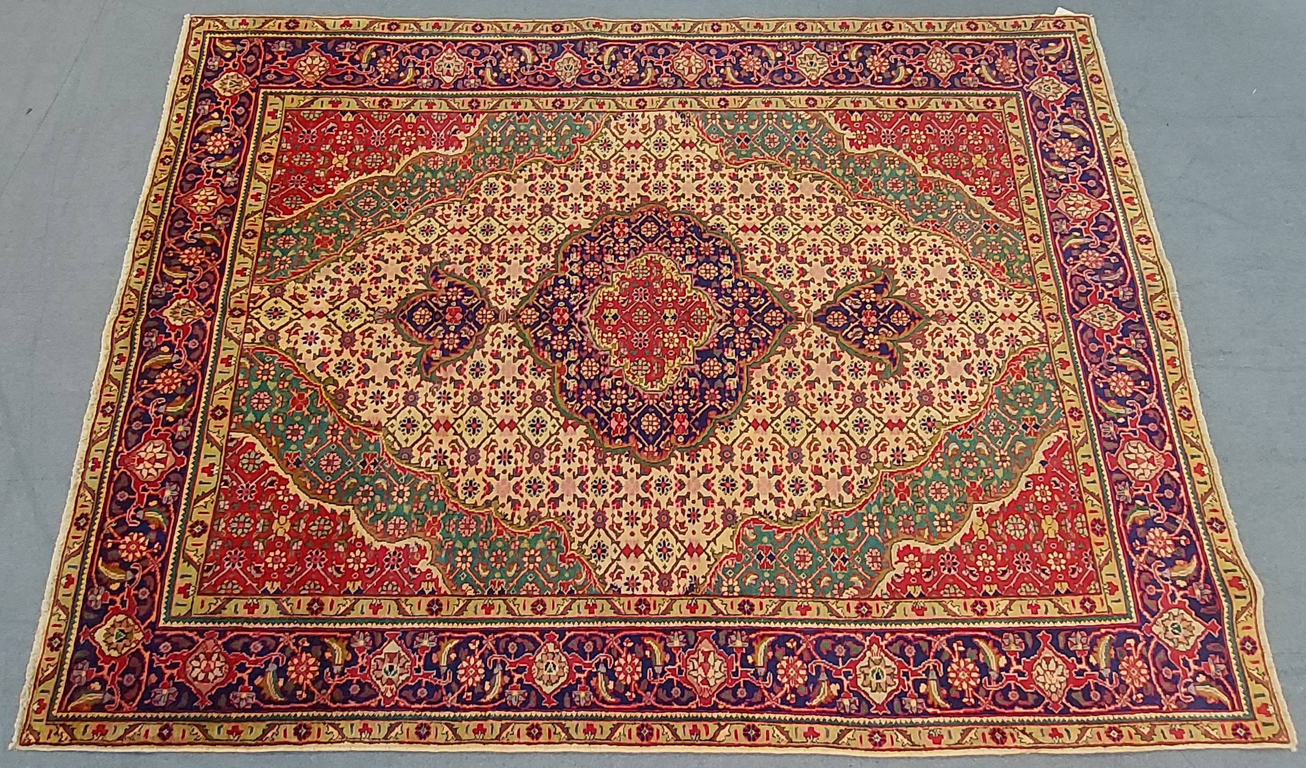 A NORTH WEST PERSIAN TABRIZ CARPET, with a central medallion surrounded by floral motifs, within wi